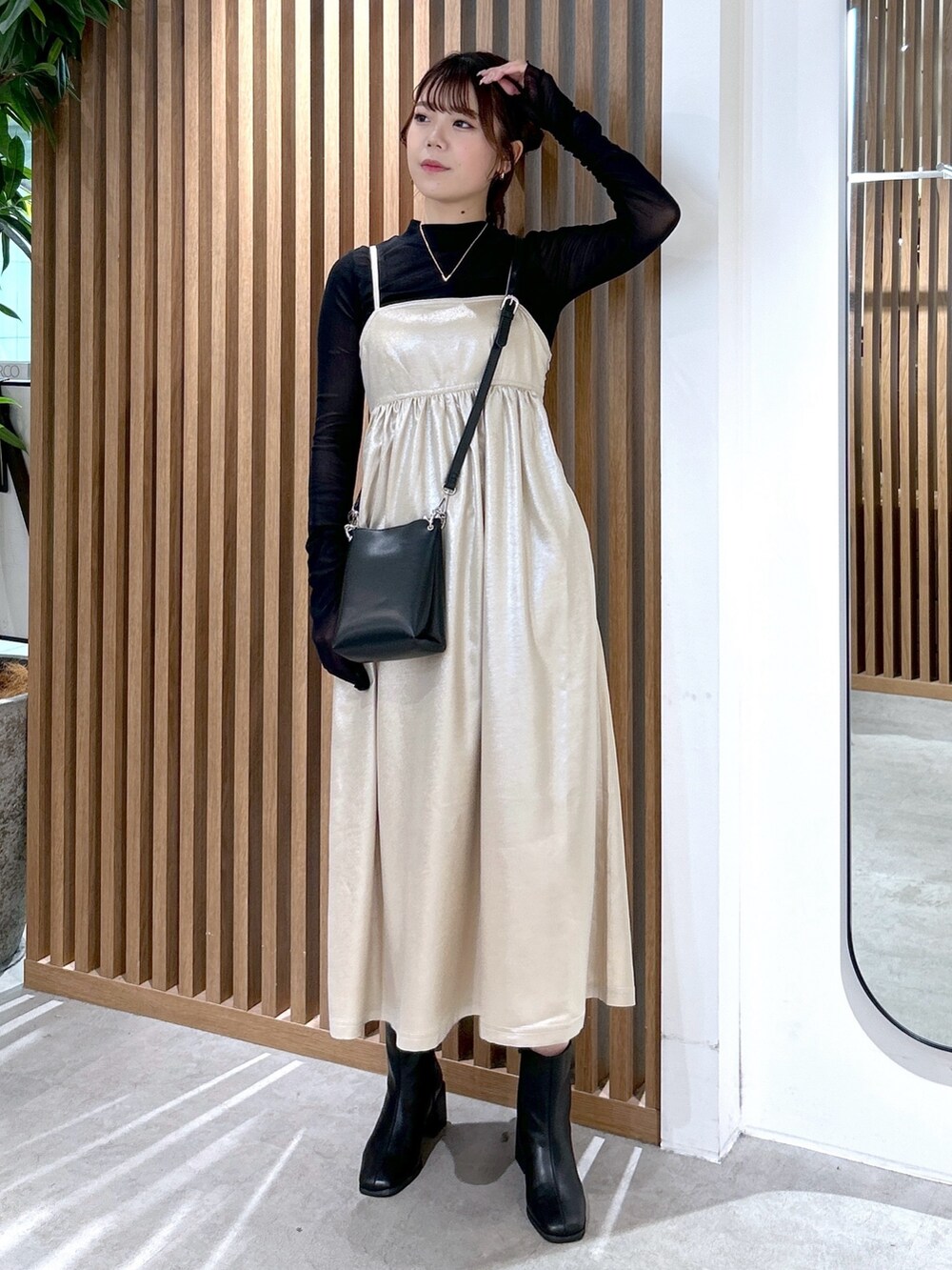 ブラック系のTシャツ/カットソー、ブラック系のショルダーバッグ、ベージュ系のワンピースを着用したレディースの冬コーディネートの2枚目の写真