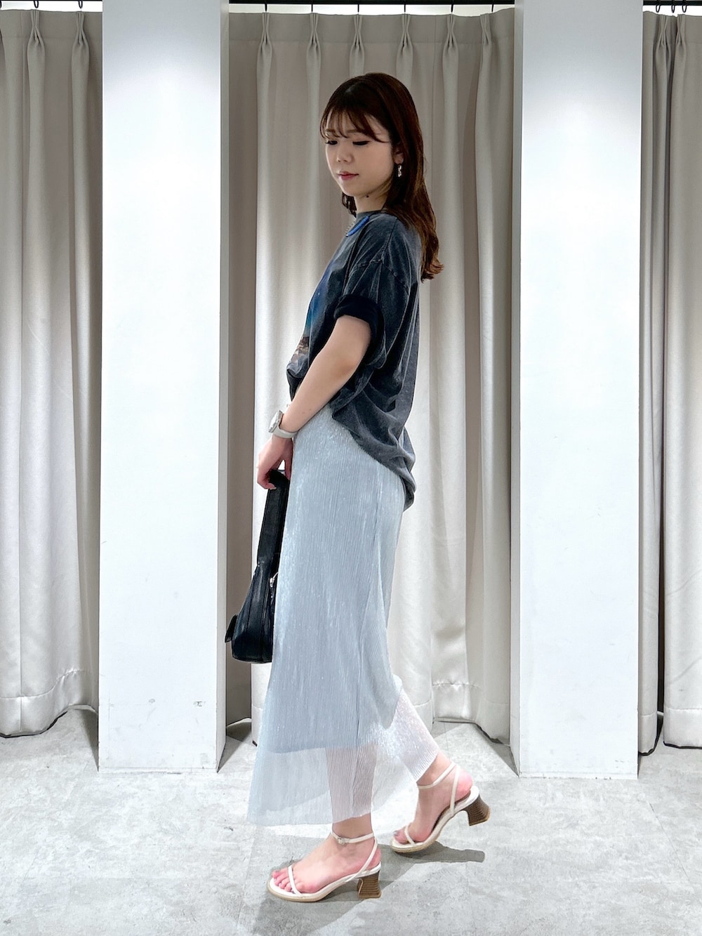 ブラック系のTシャツ/カットソー、シルバー系のスカート、ブラック系のショルダーバッグを着用したレディースの夏コーディネートの3枚目の写真