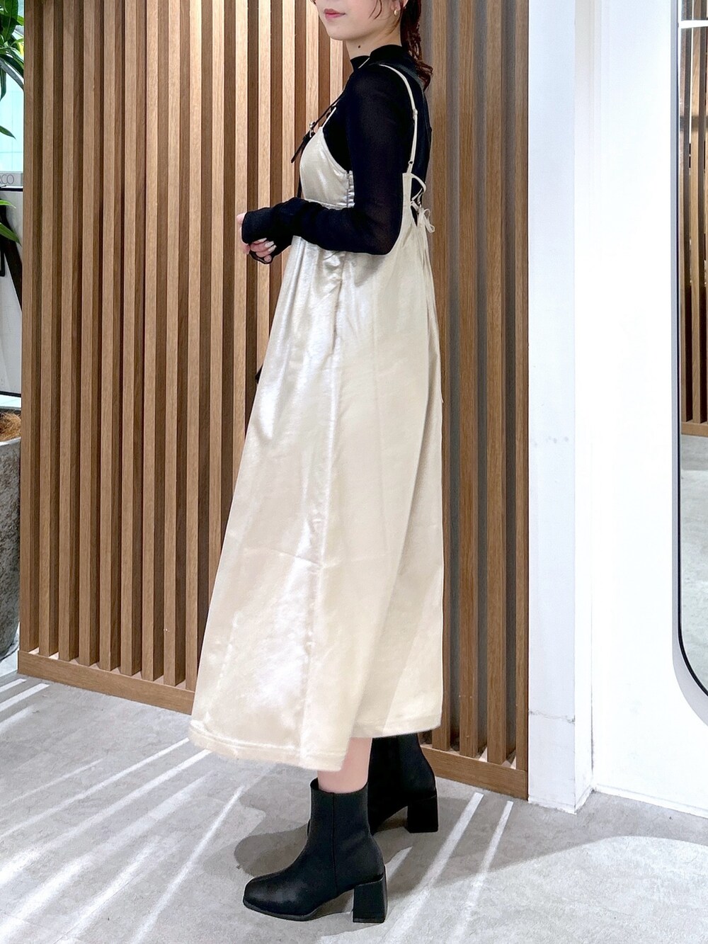 ブラック系のTシャツ/カットソー、ブラック系のショルダーバッグ、ベージュ系のワンピースを着用したレディースの冬コーディネートの3枚目の写真