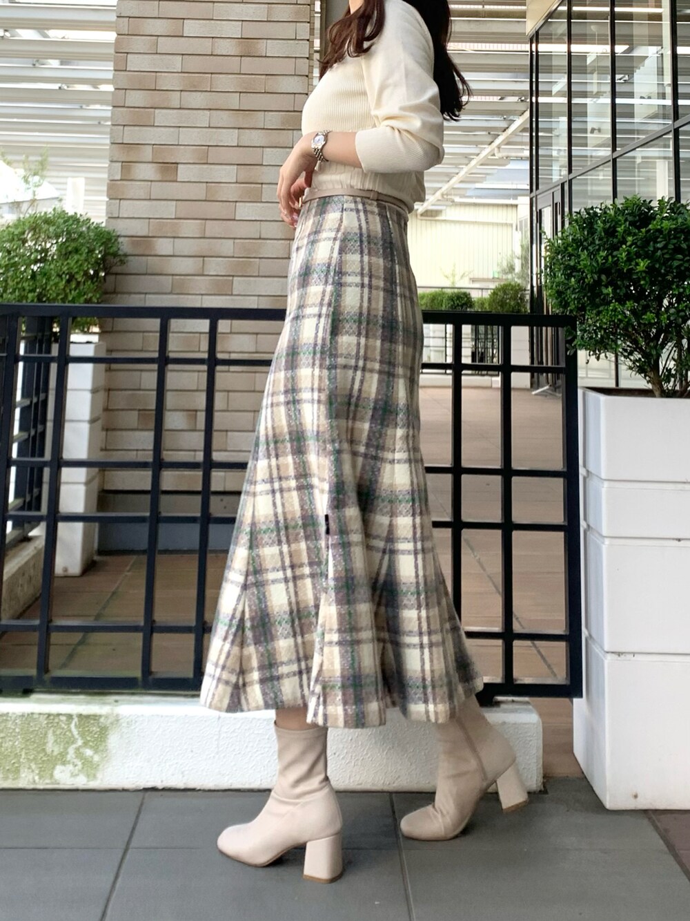 ホワイト系のニット/セーター、グリーン系のスカート、ホワイト系のシューズを着用したレディースの秋コーディネートの2枚目の写真