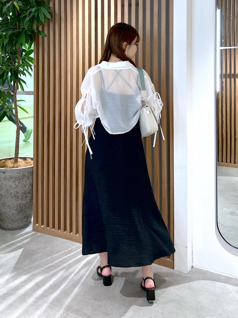 ブラック系のワンピース、ホワイト系のショルダーバッグ、ブラック系のキャミソールを着用したレディースの夏コーディネートの4枚目の写真