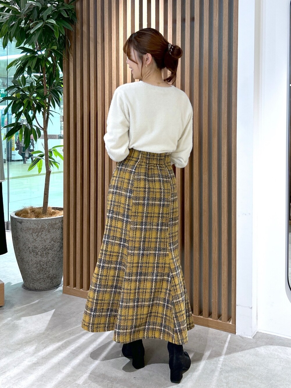 ホワイト系のニット/セーター、イエロー系のスカート、ブラック系のショルダーバッグを着用したレディースの秋コーディネートの4枚目の写真