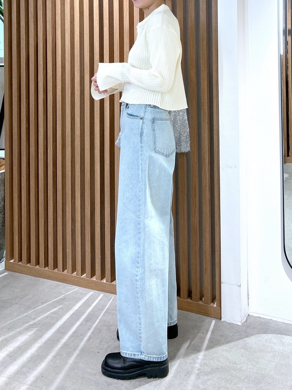 ホワイト系のニット/セーター、シルバー系のトートバッグ、ブルー系のデニムパンツを着用したレディースの冬コーディネートの3枚目の写真
