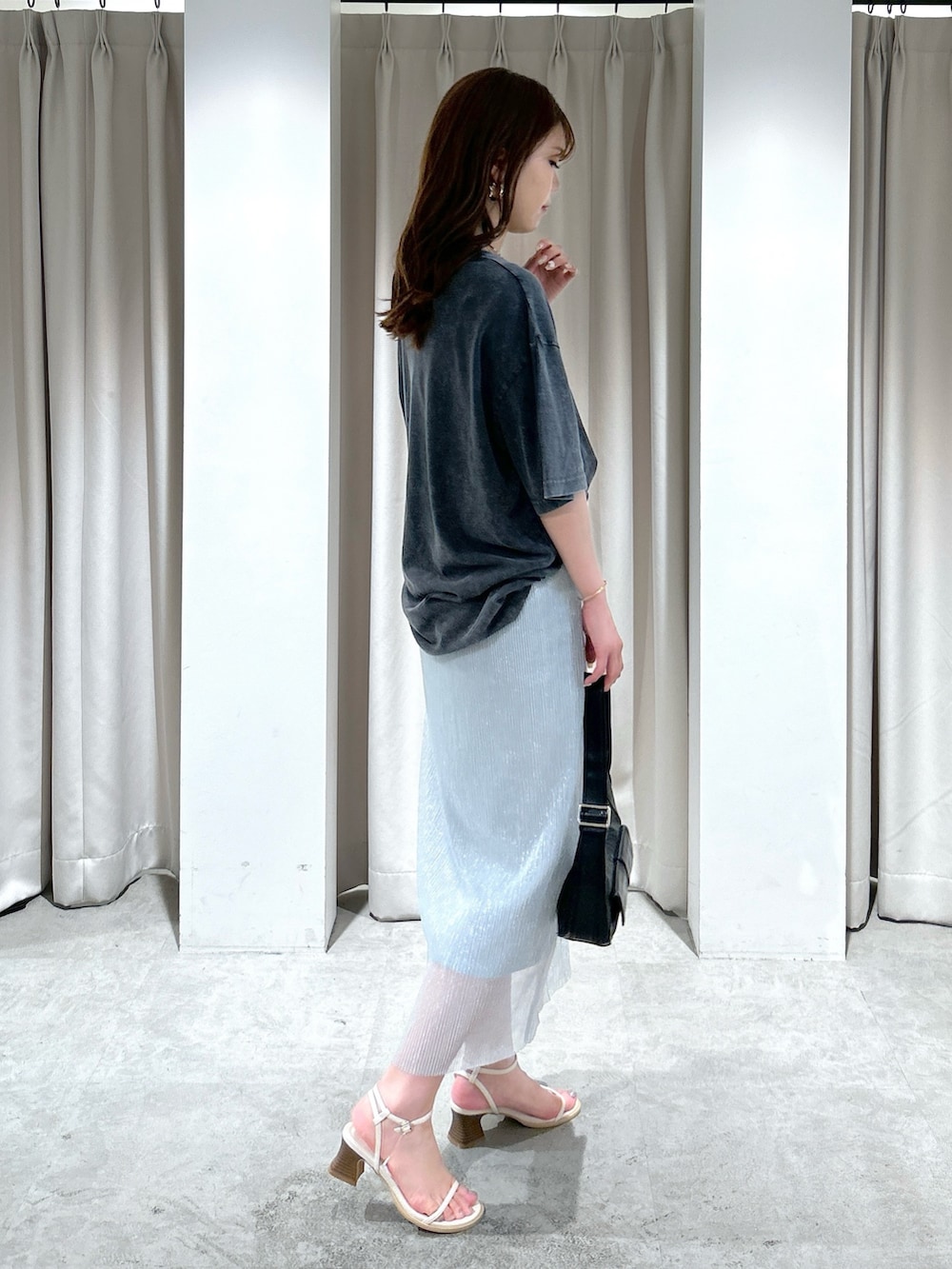 ブラック系のTシャツ/カットソー、シルバー系のスカート、ブラック系のショルダーバッグを着用したレディースの夏コーディネートの4枚目の写真