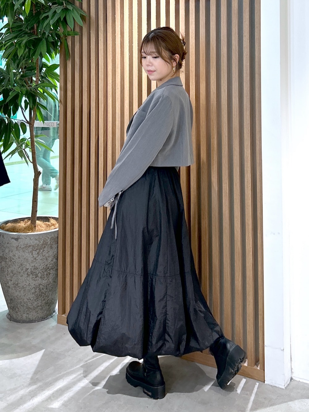 ホワイト系のTシャツ/カットソー、グレー系のテーラードジャケット、ブラック系のスカートを着用したレディースの秋コーディネートの3枚目の写真