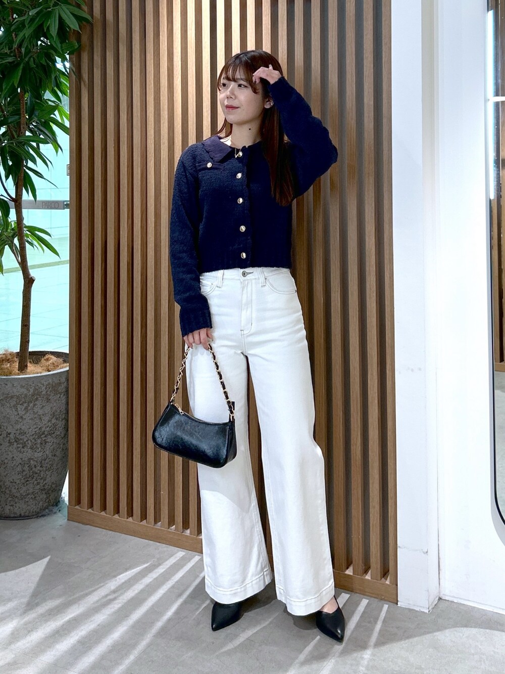 ブルー系のカーディガン/ボレロ、ブラック系のトートバッグ、ホワイト系のデニムパンツを着用したレディースの冬コーディネートの2枚目の写真