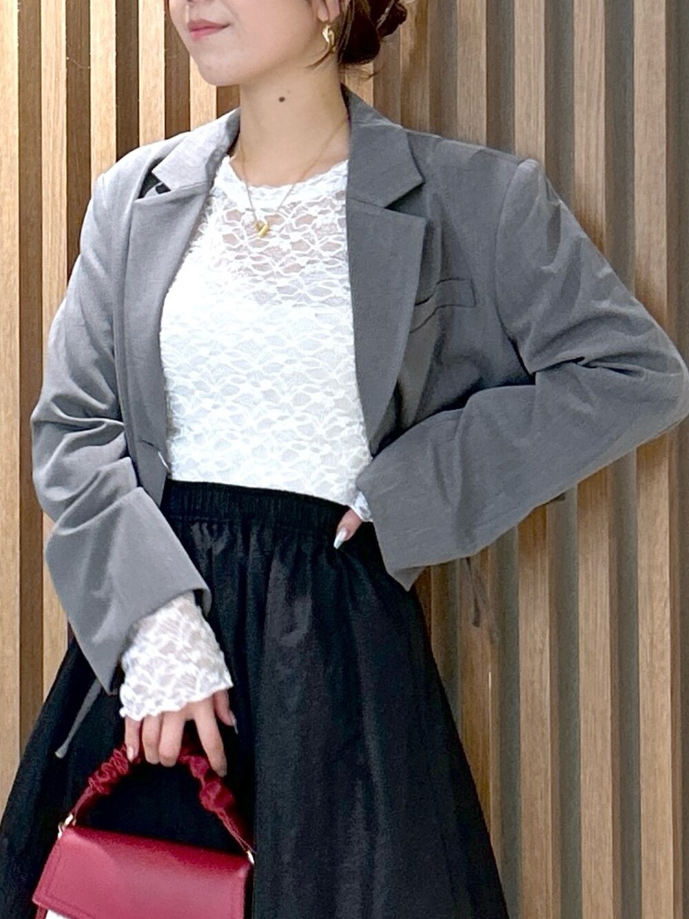 ホワイト系のTシャツ/カットソー、グレー系のテーラードジャケット、ブラック系のスカートを着用したレディースの秋コーディネートの5枚目の写真