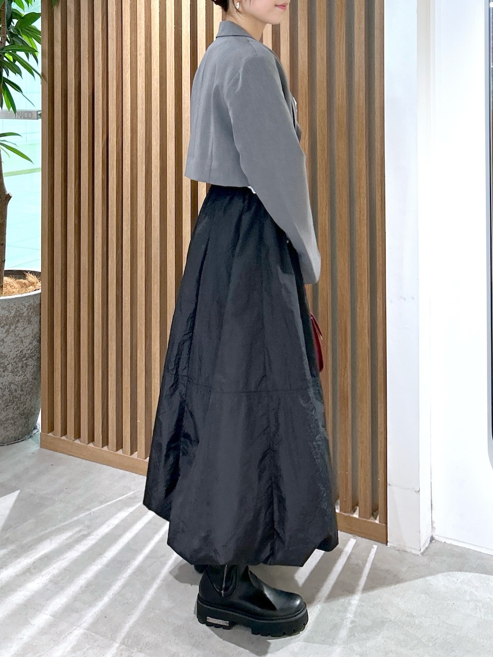 ホワイト系のTシャツ/カットソー、グレー系のテーラードジャケット、ブラック系のスカートを着用したレディースの秋コーディネートの2枚目の写真