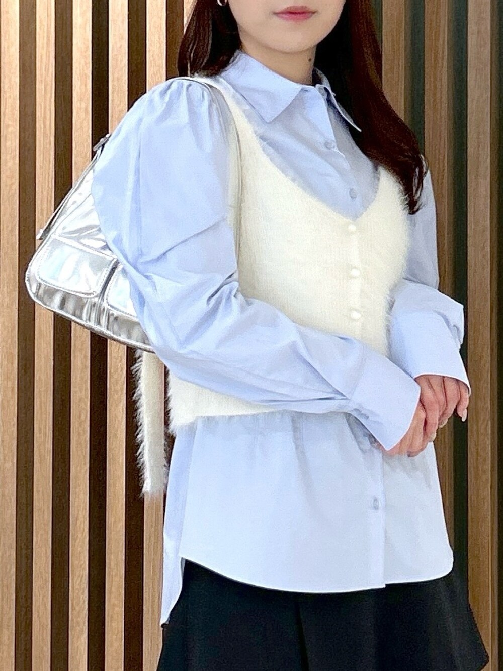 ホワイト系のベスト、ブルー系のシャツ/ブラウス、シルバー系のショルダーバッグを着用したレディースの冬コーディネートの5枚目の写真