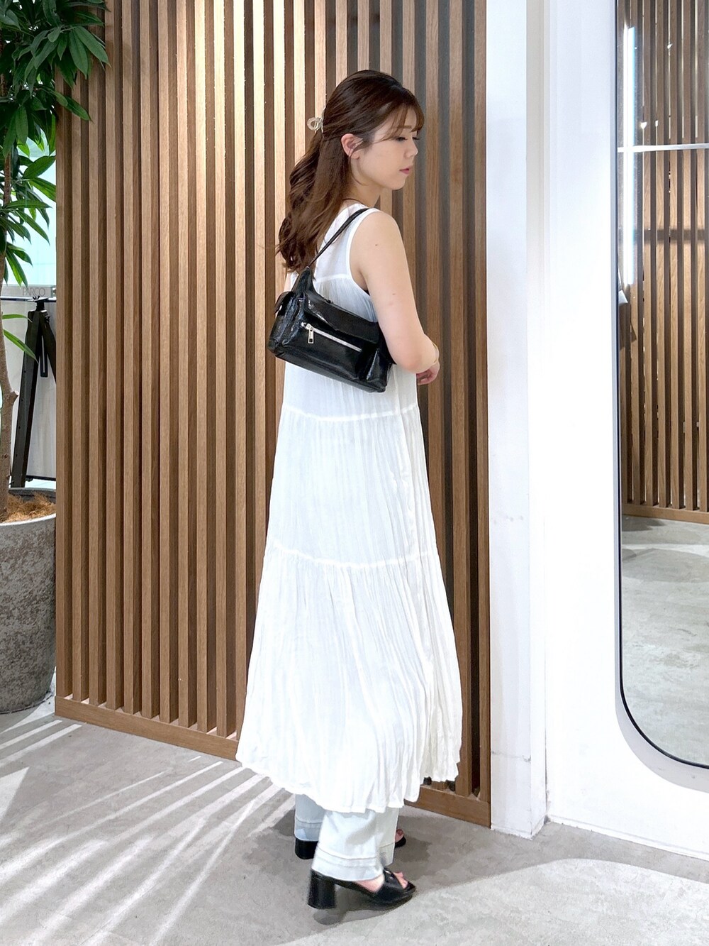 ホワイト系のワンピース、ブラック系のキャミソール、ブラック系のハンドバッグを着用したレディースの夏コーディネートの4枚目の写真