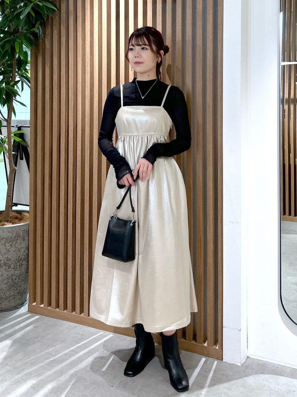 ブラック系のTシャツ/カットソー、ブラック系のショルダーバッグ、ベージュ系のワンピースを着用したレディースの冬コーディネートの5枚目の写真