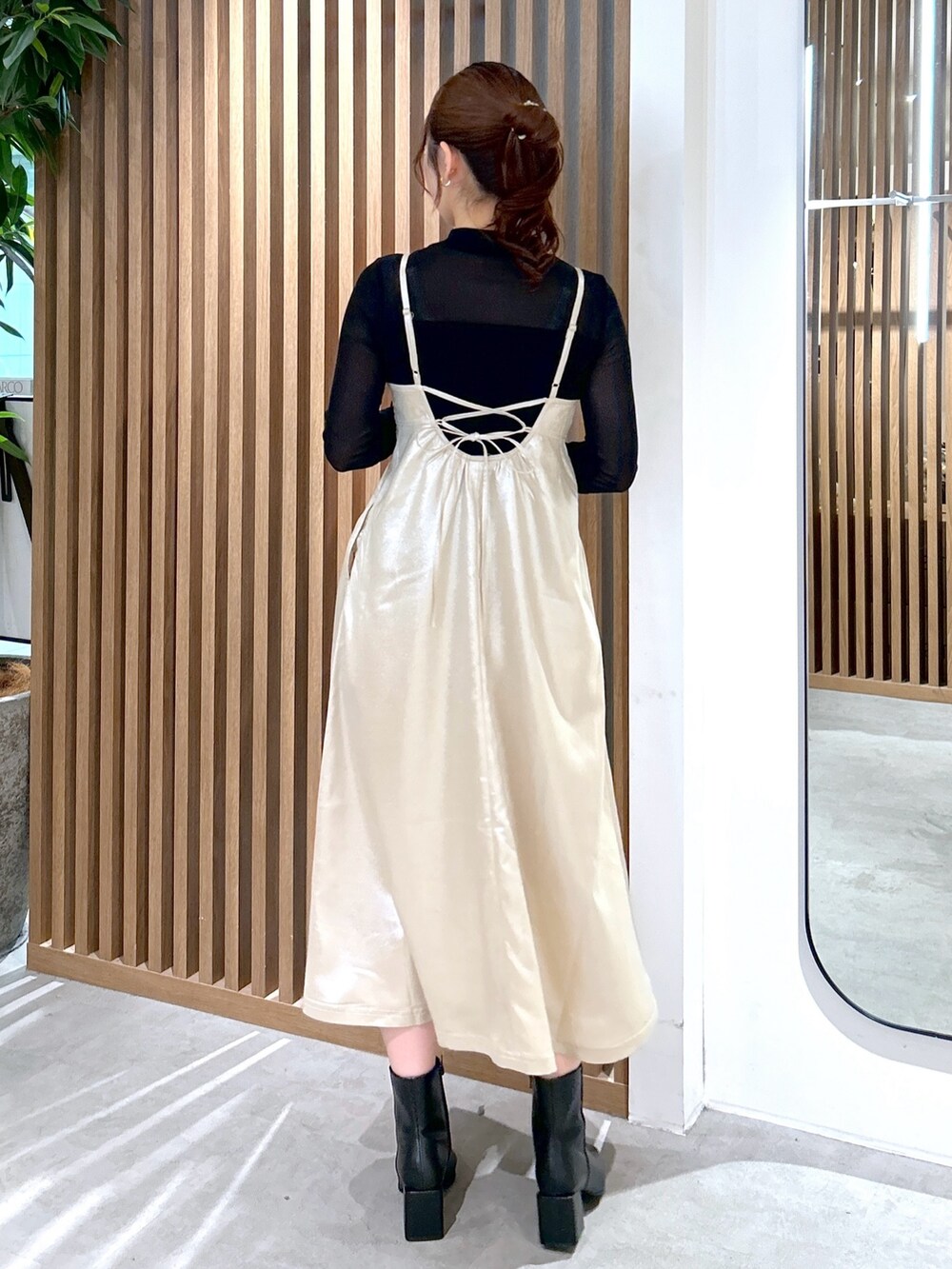 ブラック系のTシャツ/カットソー、ブラック系のショルダーバッグ、ベージュ系のワンピースを着用したレディースの冬コーディネートの4枚目の写真