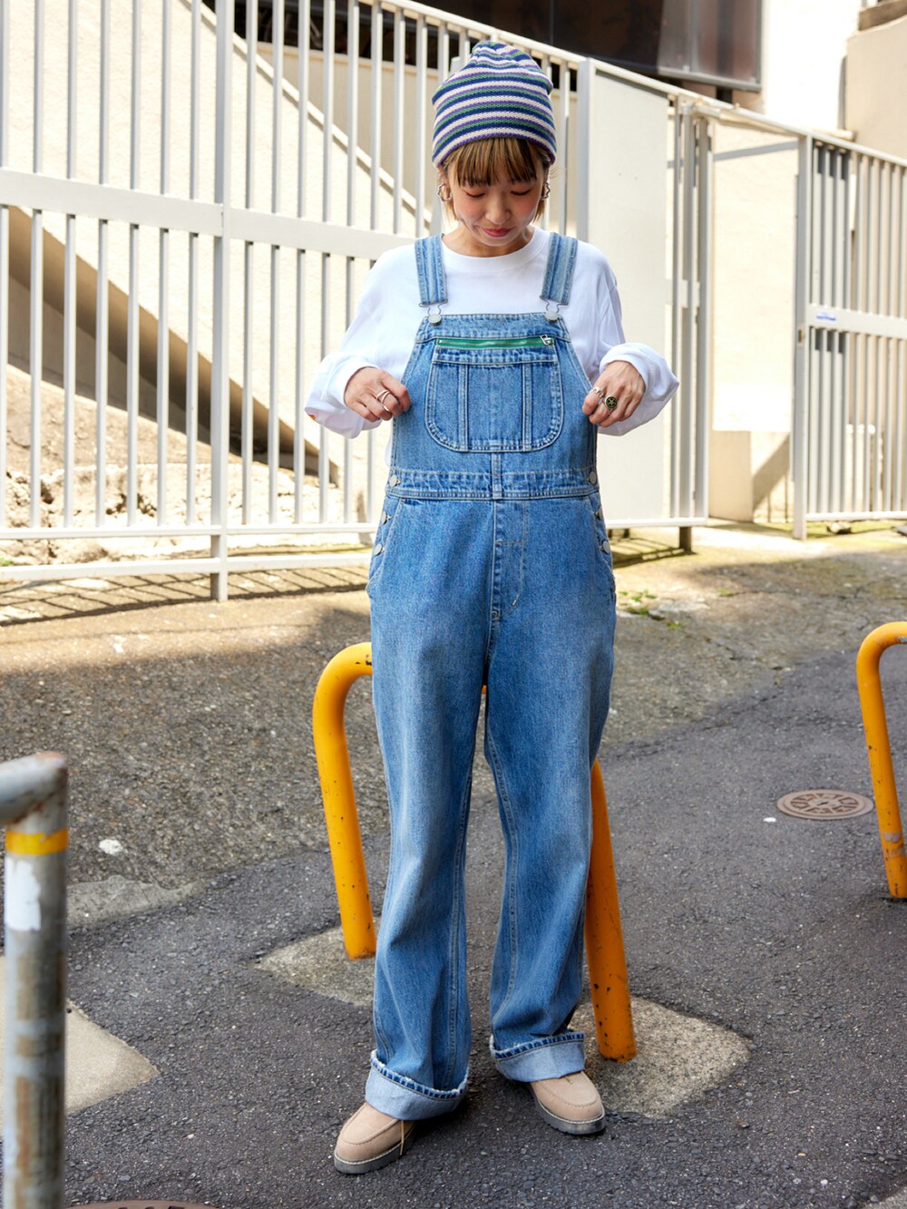 ブルー系のサロペット/オーバーオール、ホワイト系のTシャツ/カットソー、ブラック系のライダースジャケットを着用したレディースの秋コーディネートの2枚目の写真