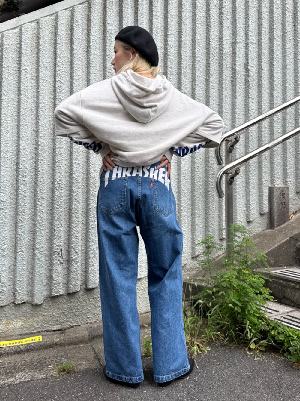 グレー系のパーカー、ブルー系のデニムパンツを着用したレディースの秋コーディネートの2枚目の写真