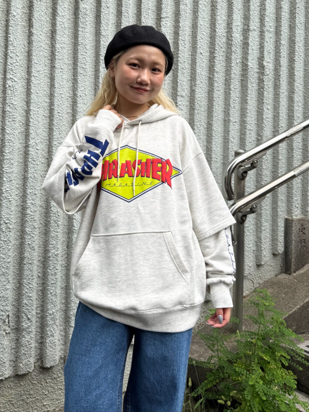 グレー系のパーカー、ブルー系のデニムパンツを着用したレディースの秋コーディネートの3枚目の写真