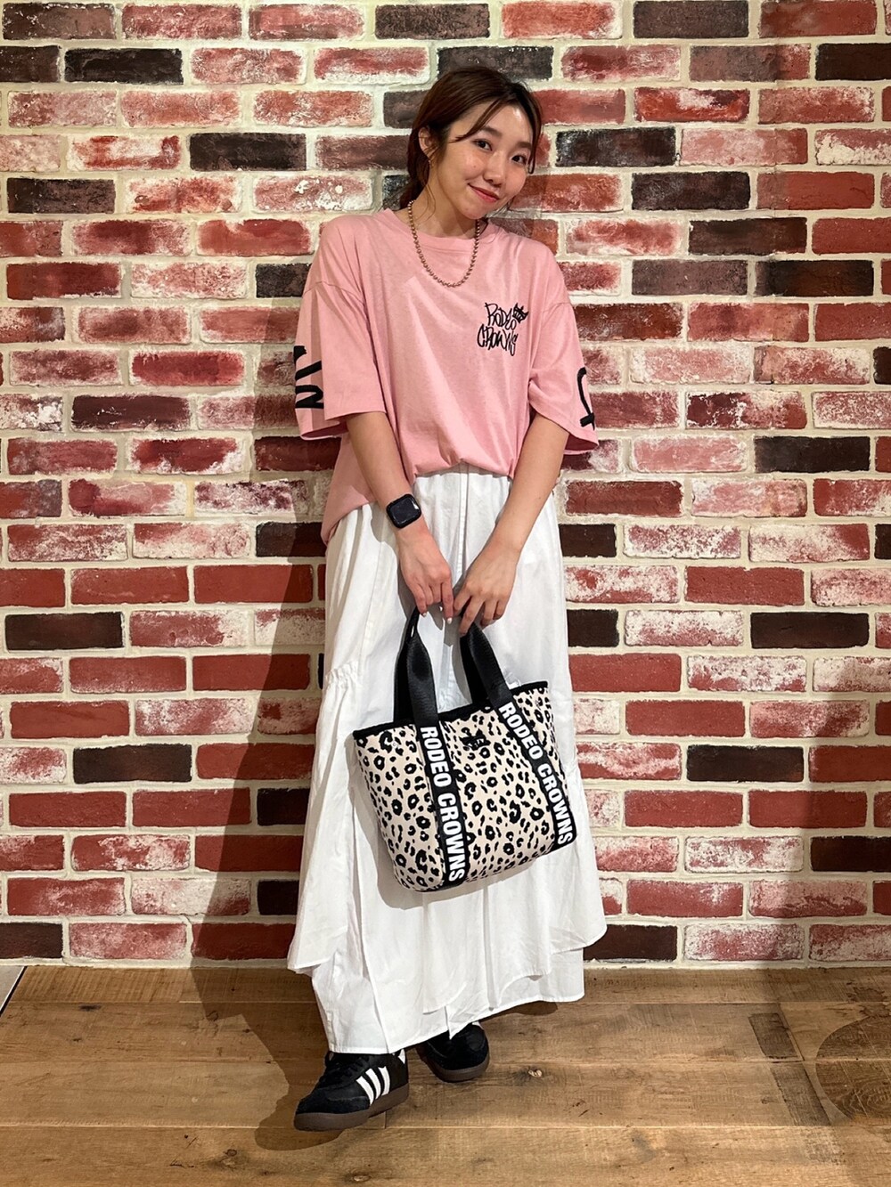 ピンク系のTシャツ/カットソー、ホワイト系のトートバッグ、ホワイト系のスカートを着用したレディースの夏コーディネートの2枚目の写真