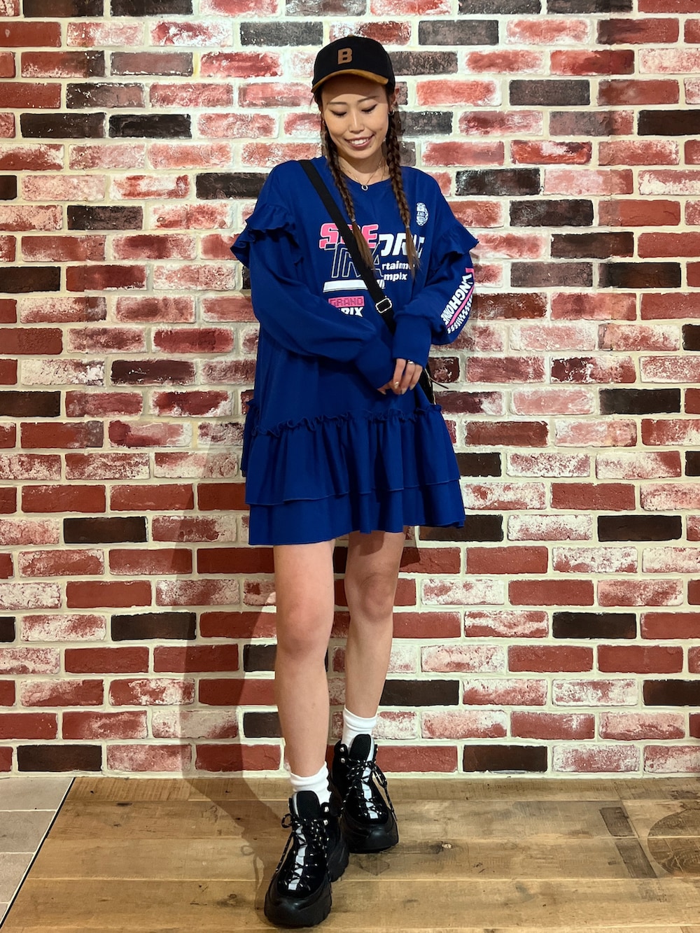 ブルー系のチュニック、ブラック系のスニーカーを着用したレディースの秋コーディネートの2枚目の写真