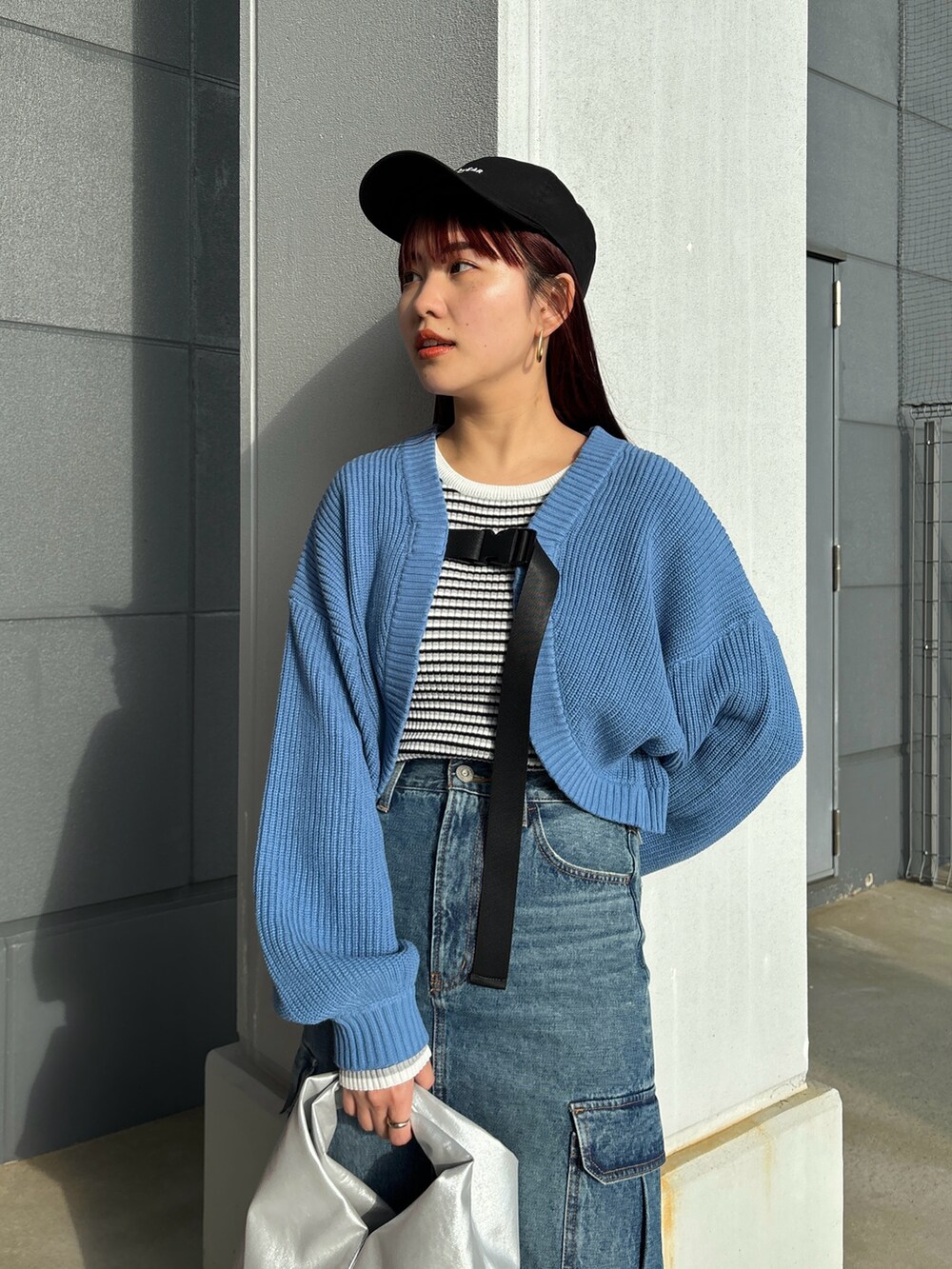 ブルー系のカーディガン/ボレロ、ブルー系のデニムスカート、シルバー系のトートバッグを着用したレディースの冬コーディネートの3枚目の写真