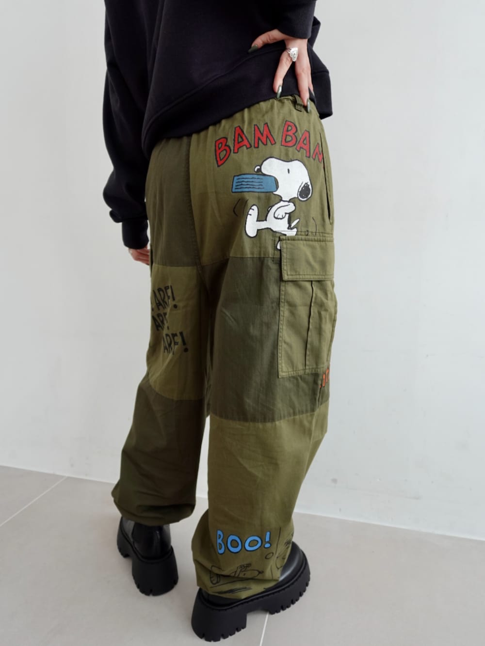 グリーン系のカーゴパンツ、ブラック系のパーカーを着用したレディースの秋コーディネートの4枚目の写真