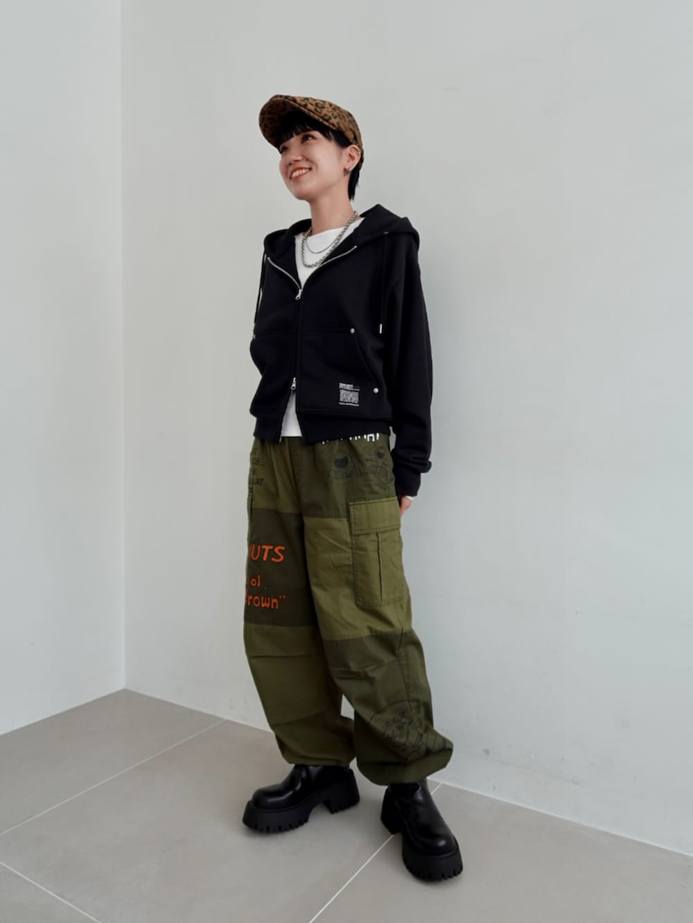 グリーン系のカーゴパンツ、ブラック系のパーカーを着用したレディースの秋コーディネートの2枚目の写真