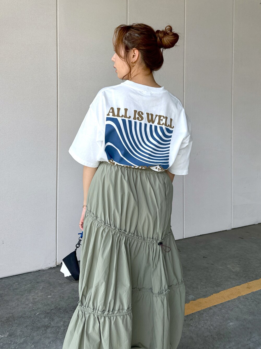 ホワイト系のTシャツ/カットソー、グリーン系のスカート、ブラック系のショルダーバッグを着用したレディースの夏コーディネートの2枚目の写真