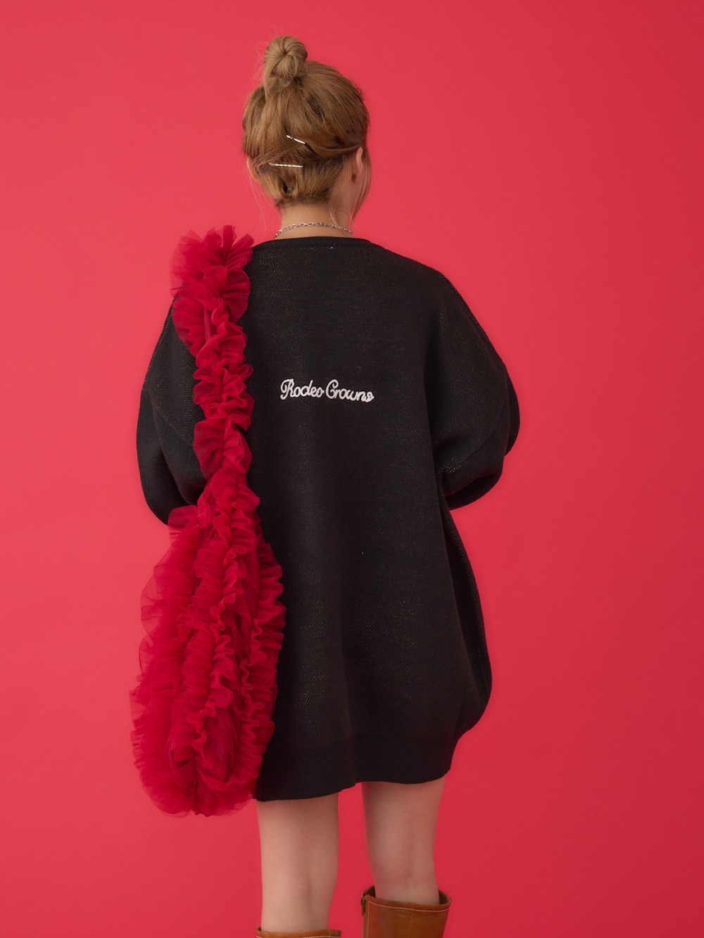 ブラック系のワンピース、レッド系のショルダーバッグ、ブラウン系のブーツを着用したレディースの冬コーディネートの4枚目の写真