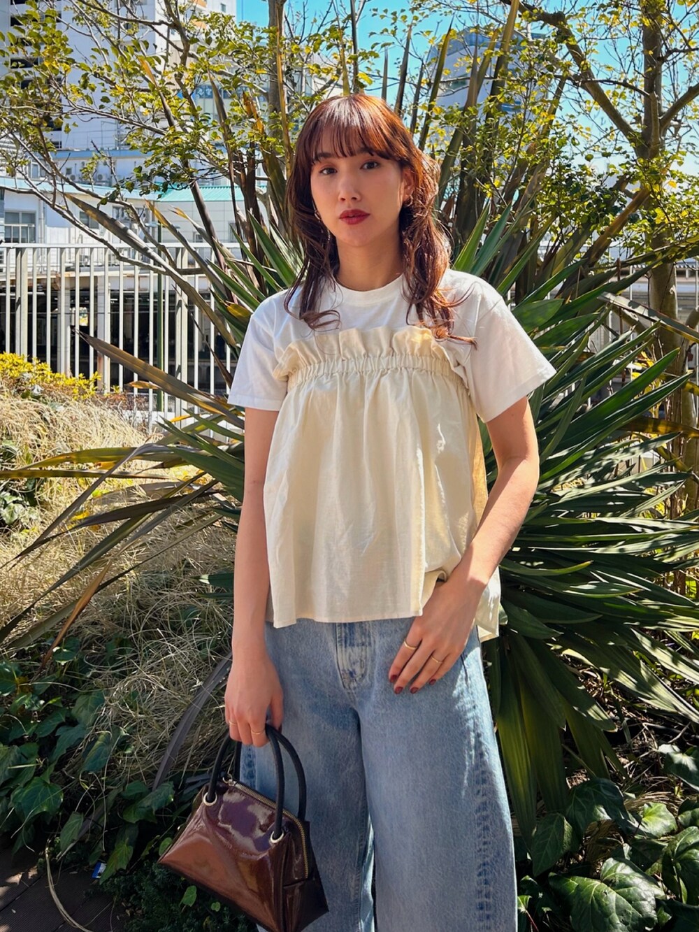 ホワイト系のTシャツ/カットソー、ブルー系のデニムパンツを着用したレディースの春コーディネートの2枚目の写真