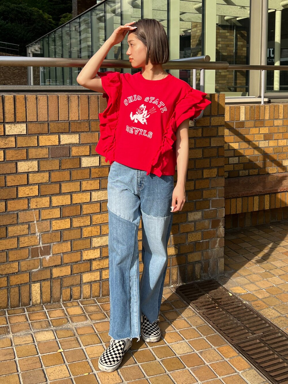 レッド系のTシャツ/カットソー、ブルー系のデニムパンツを着用したレディースの春コーディネートの2枚目の写真