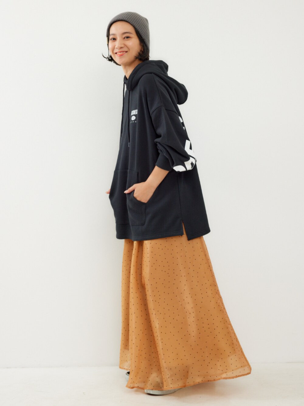 ブラック系のパーカー、ブラウン系のスカートを着用したレディースの秋コーディネートの2枚目の写真