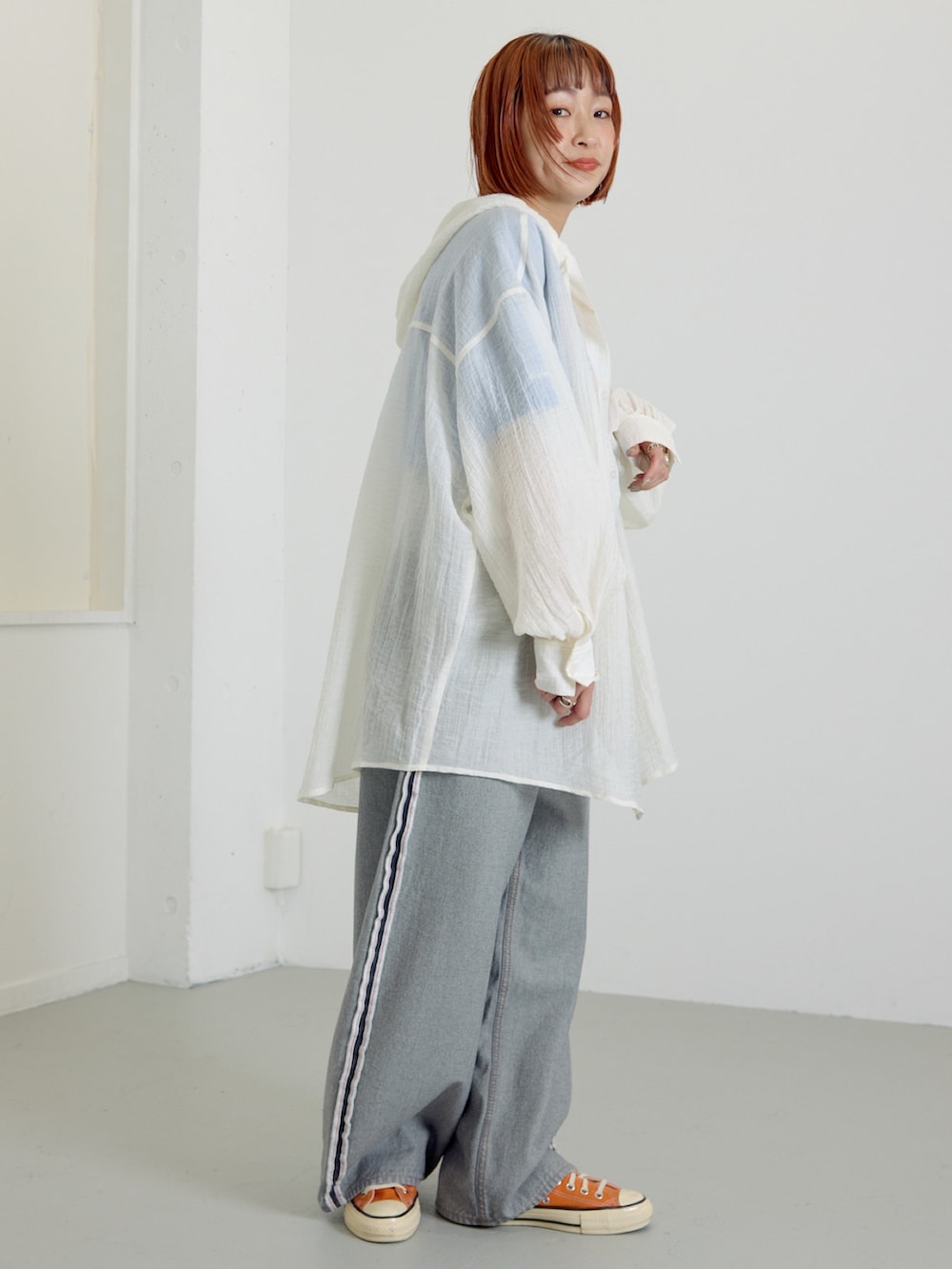 ブラック系のデニムパンツ、ホワイト系のシャツ/ブラウス、ブルー系のTシャツ/カットソーを着用したレディースの春コーディネートの2枚目の写真