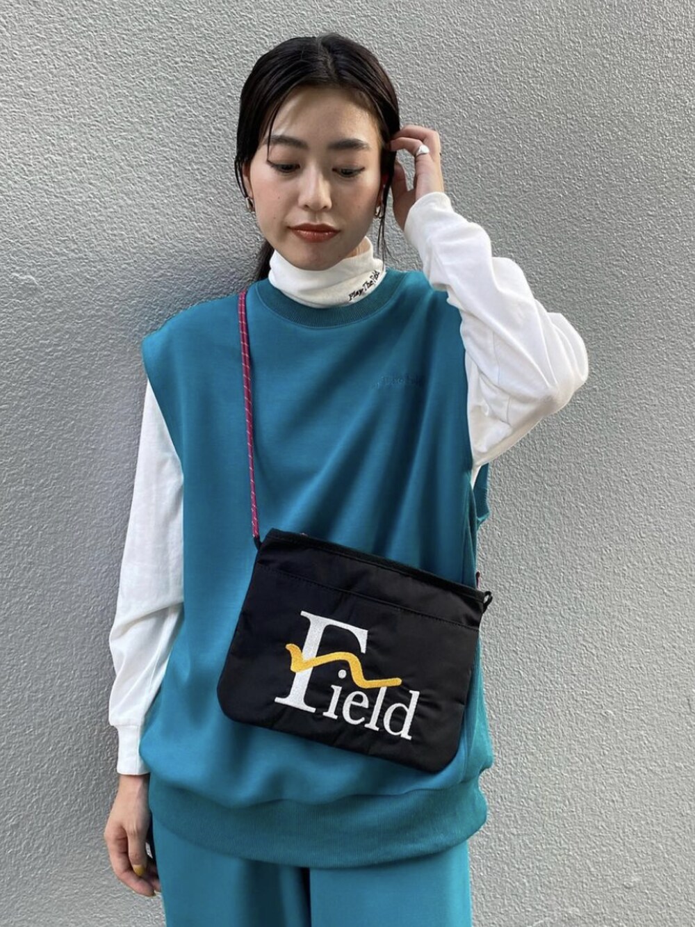 ブルー系のベスト、ブルー系のその他パンツ、ブラック系のショルダーバッグを着用したレディースの秋コーディネートの2枚目の写真