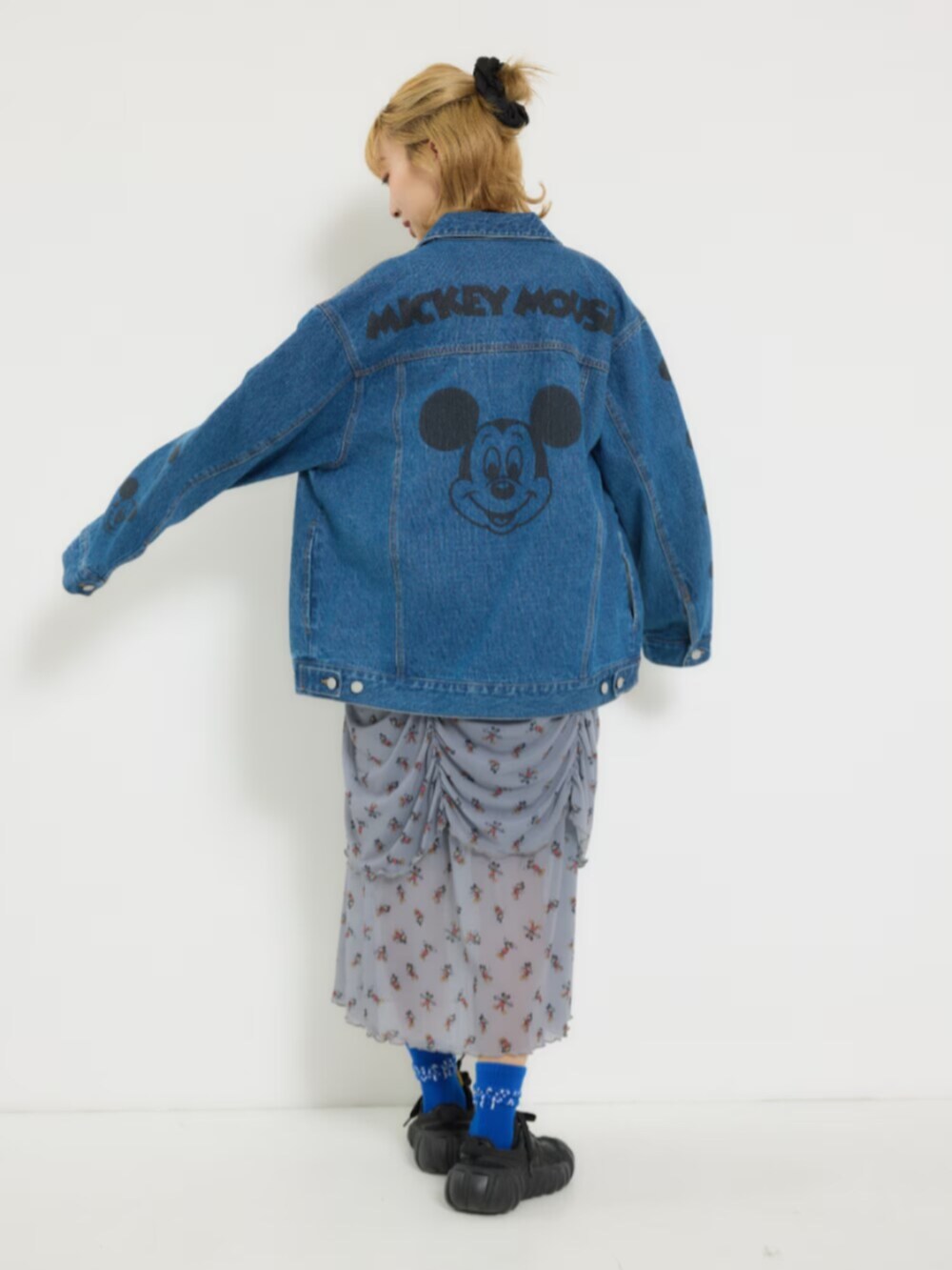 ブルー系のデニムジャケット、グレー系のワンピース、イエロー系のショルダーバッグを着用したレディースの冬コーディネートの3枚目の写真