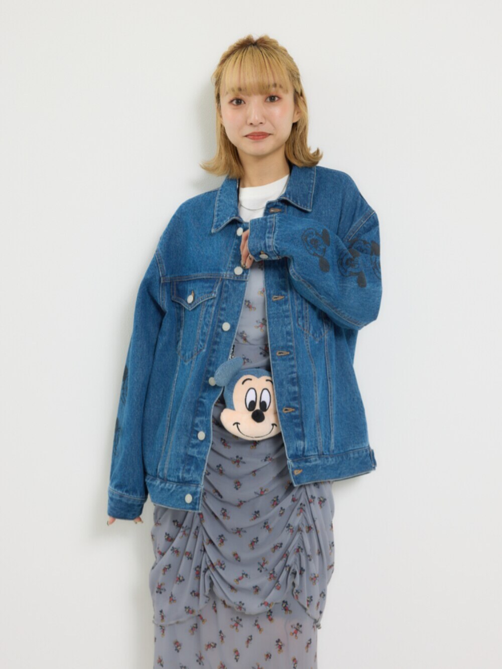 ブルー系のデニムジャケット、グレー系のワンピース、イエロー系のショルダーバッグを着用したレディースの冬コーディネートの4枚目の写真