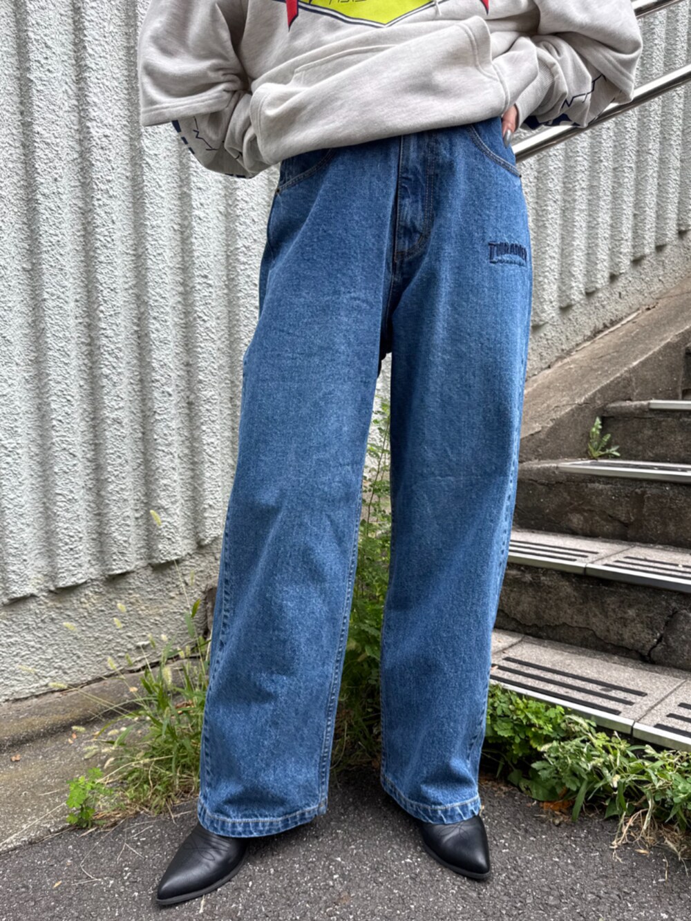 グレー系のパーカー、ブルー系のデニムパンツを着用したレディースの秋コーディネートの4枚目の写真