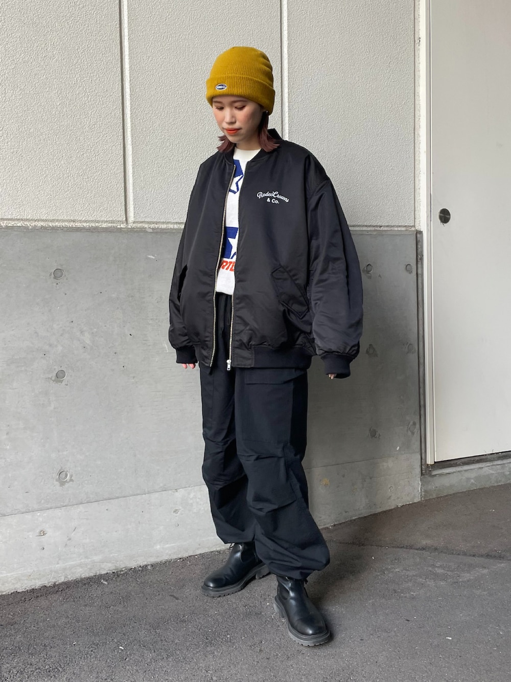 ホワイト系のニット/セーター、ブラック系のカーゴパンツ、イエロー系のニットキャップ/ビーニーを着用したレディースの冬コーディネートの3枚目の写真