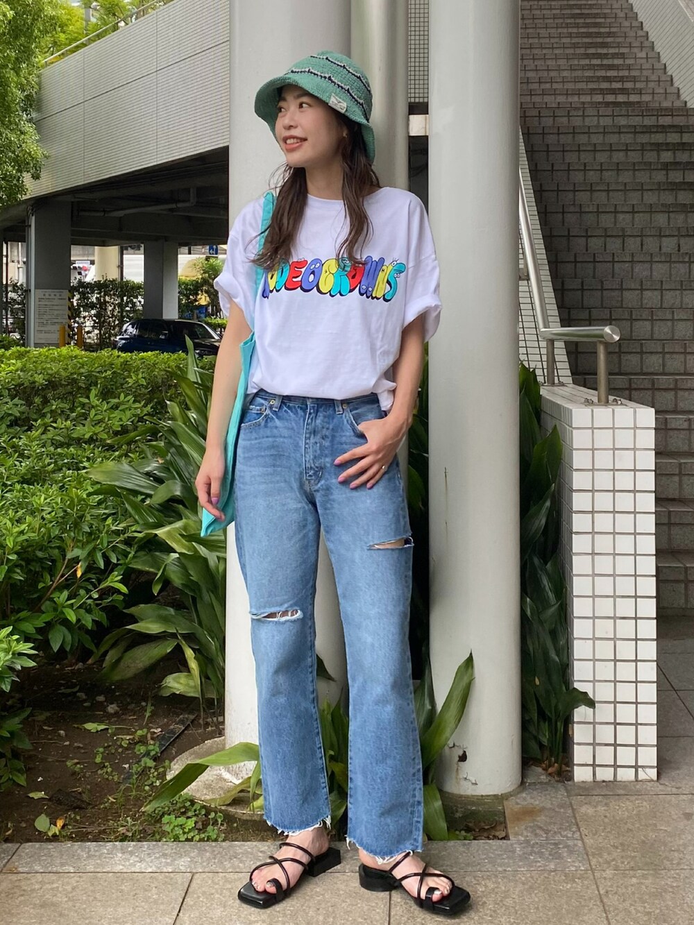ホワイト系のTシャツ/カットソー、ブルー系のトートバッグ、グリーン系のハットを着用したレディースの夏コーディネートの2枚目の写真