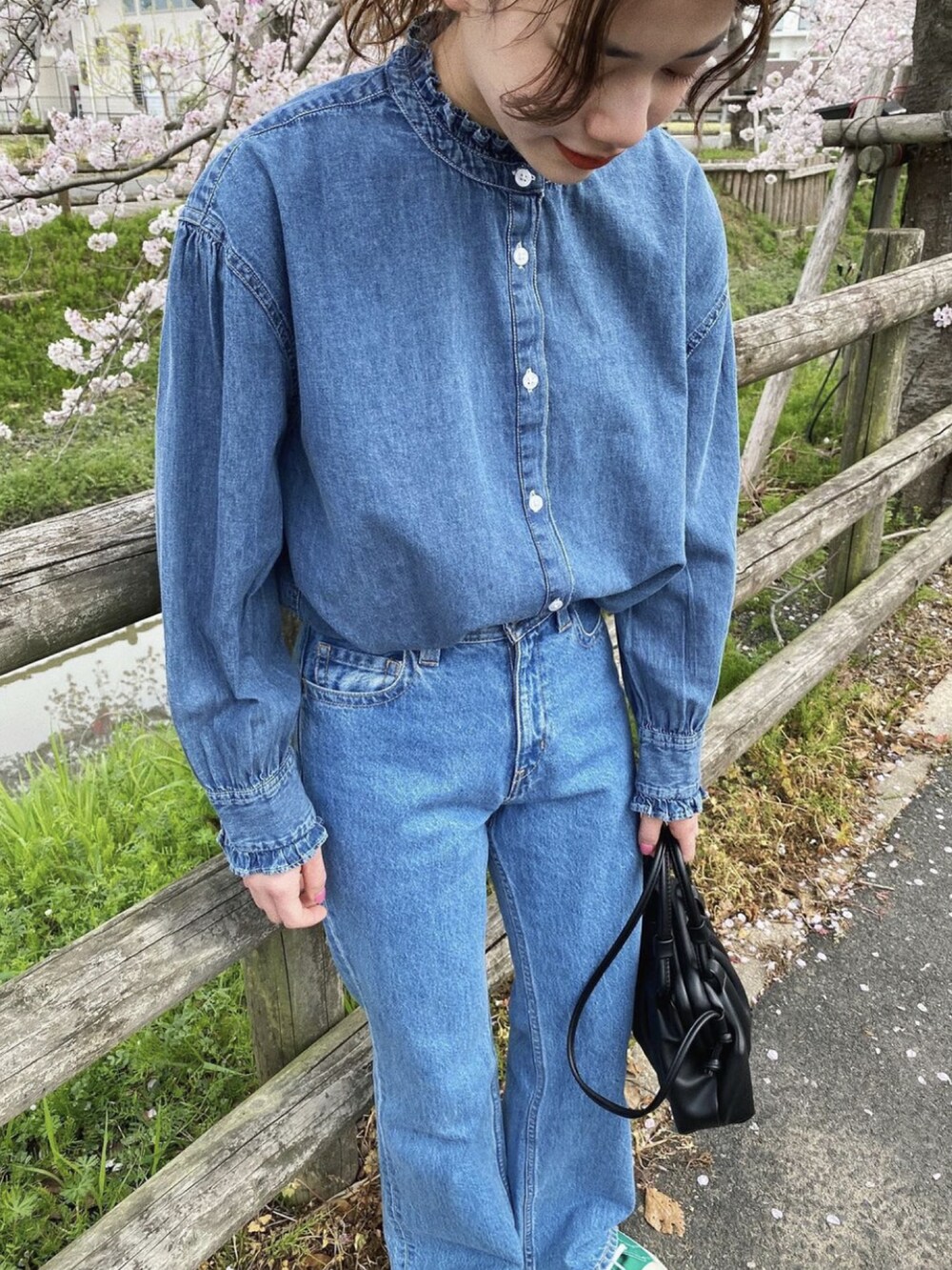 ブルー系のシャツ/ブラウス、ブラック系のショルダーバッグ、ブルー系のデニムパンツを着用したレディースの春コーディネートの3枚目の写真