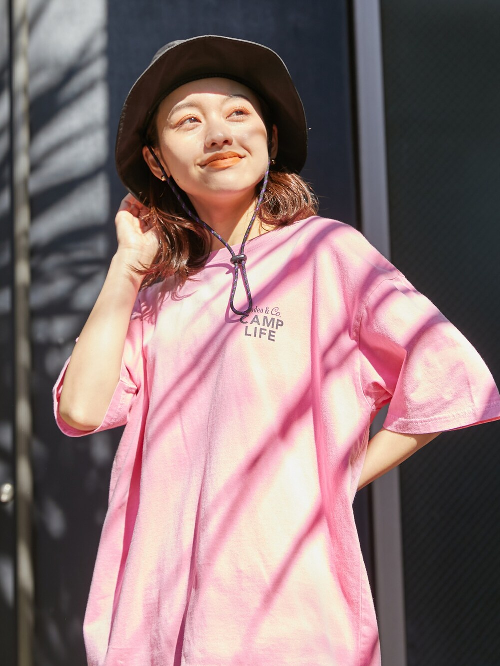 ピンク系のTシャツ/カットソー、ホワイト系のスカート、ブラック系のハットを着用したレディースの春コーディネートの2枚目の写真