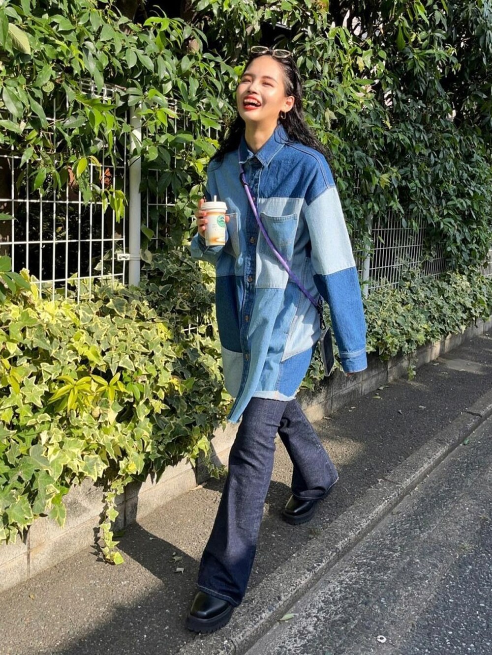 ブルー系のシャツワンピース、ブルー系のデニムパンツを着用したレディースの秋コーディネートの2枚目の写真