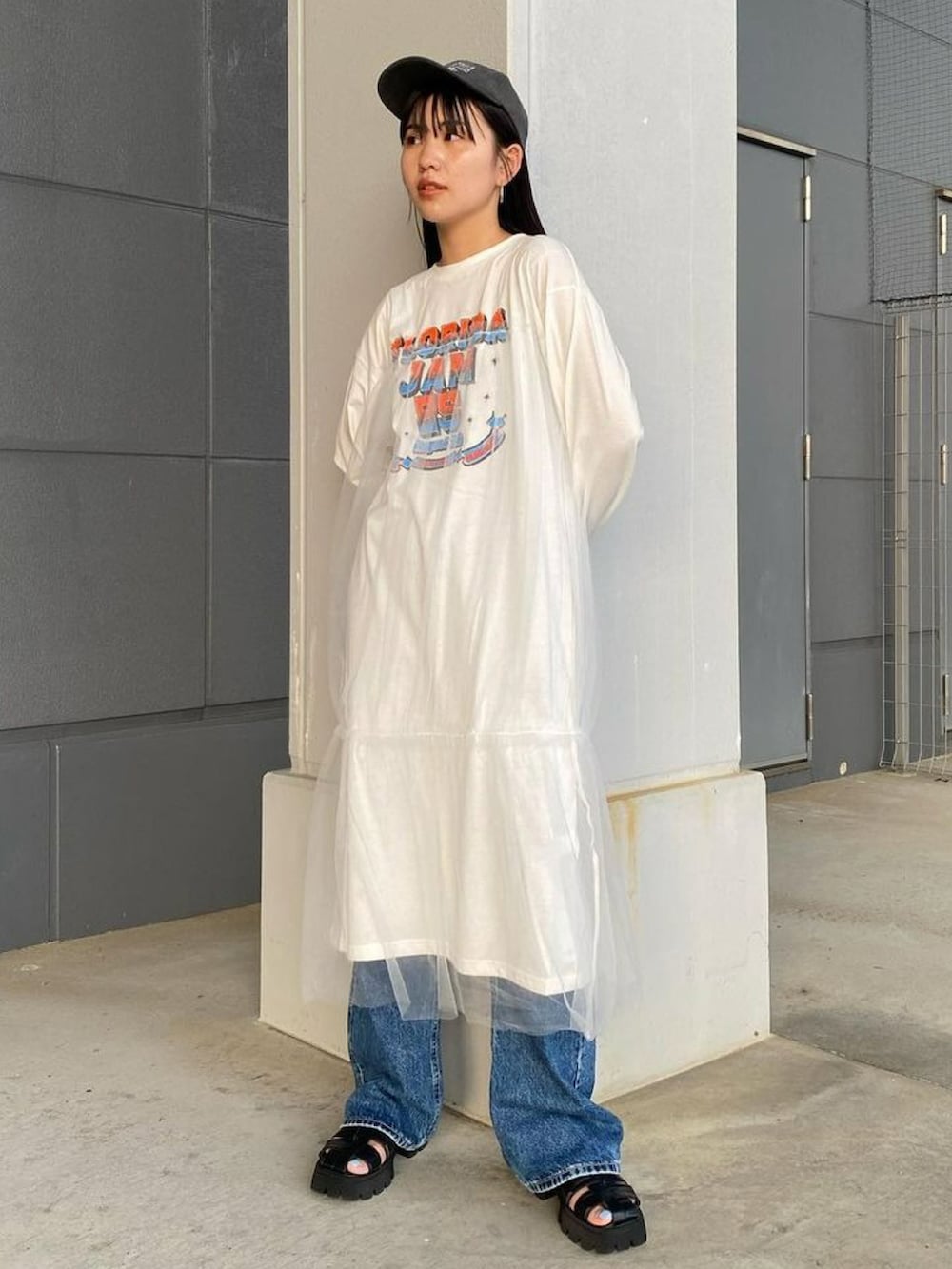 オレンジ系のベスト、ホワイト系のワンピースを着用したレディースの秋コーディネートの3枚目の写真