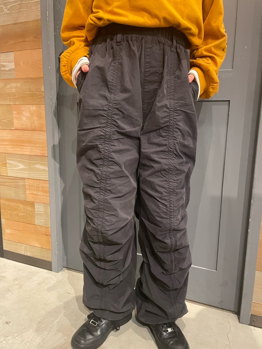 イエロー系のTシャツ/カットソー、ブラック系のその他パンツを着用したレディースの秋コーディネートの3枚目の写真