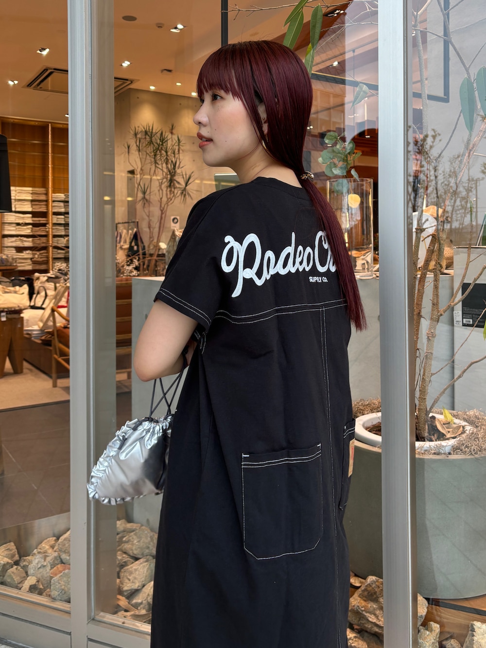 ブラック系のワンピース、オレンジ系のその他パンツ、ブルー系のサンダルを着用したレディースの春コーディネートの3枚目の写真