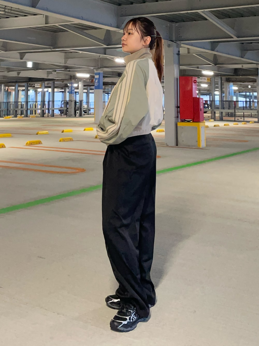 グリーン系のジャージを着用したレディースの秋コーディネートの2枚目の写真