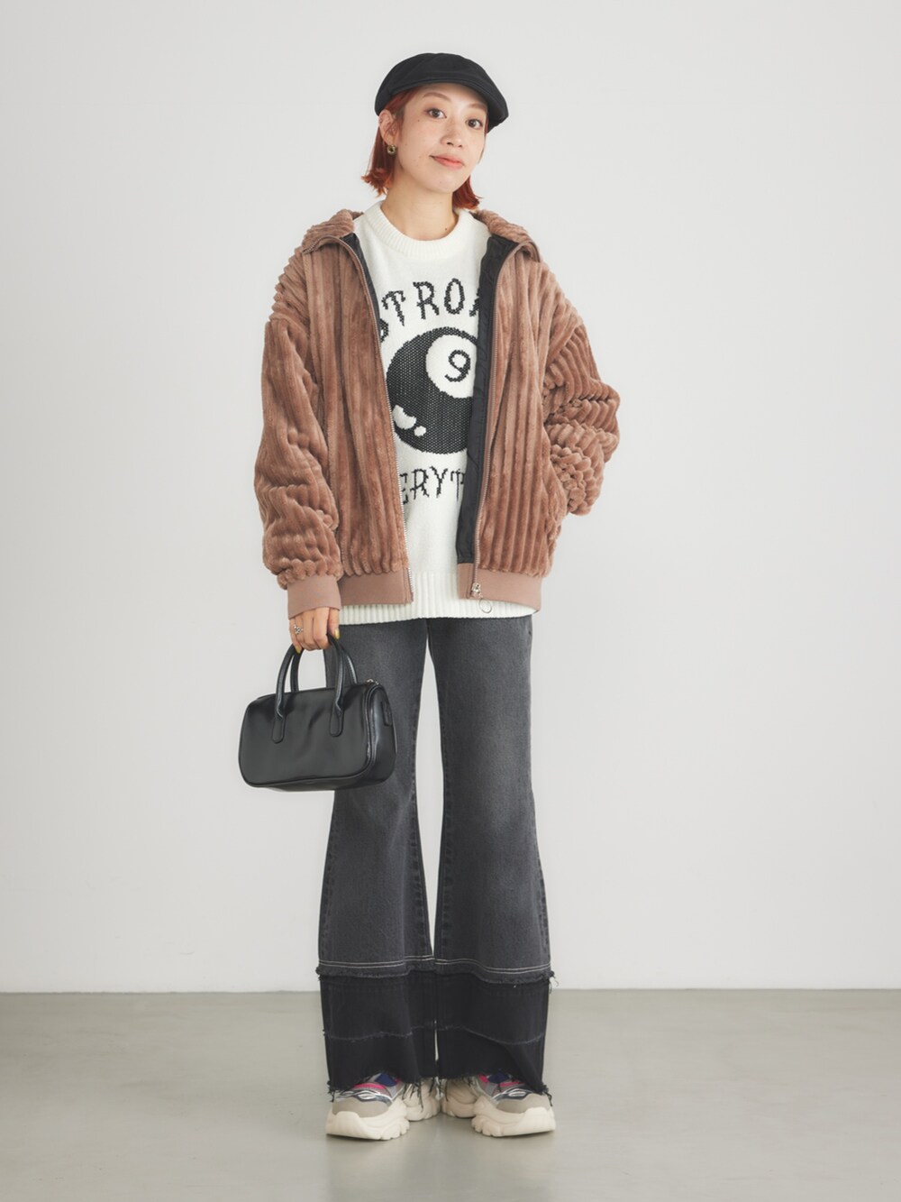 ブラウン系のブルゾン、ブラック系のデニムパンツ、シルバー系のスニーカーを着用したレディースの冬コーディネートの2枚目の写真