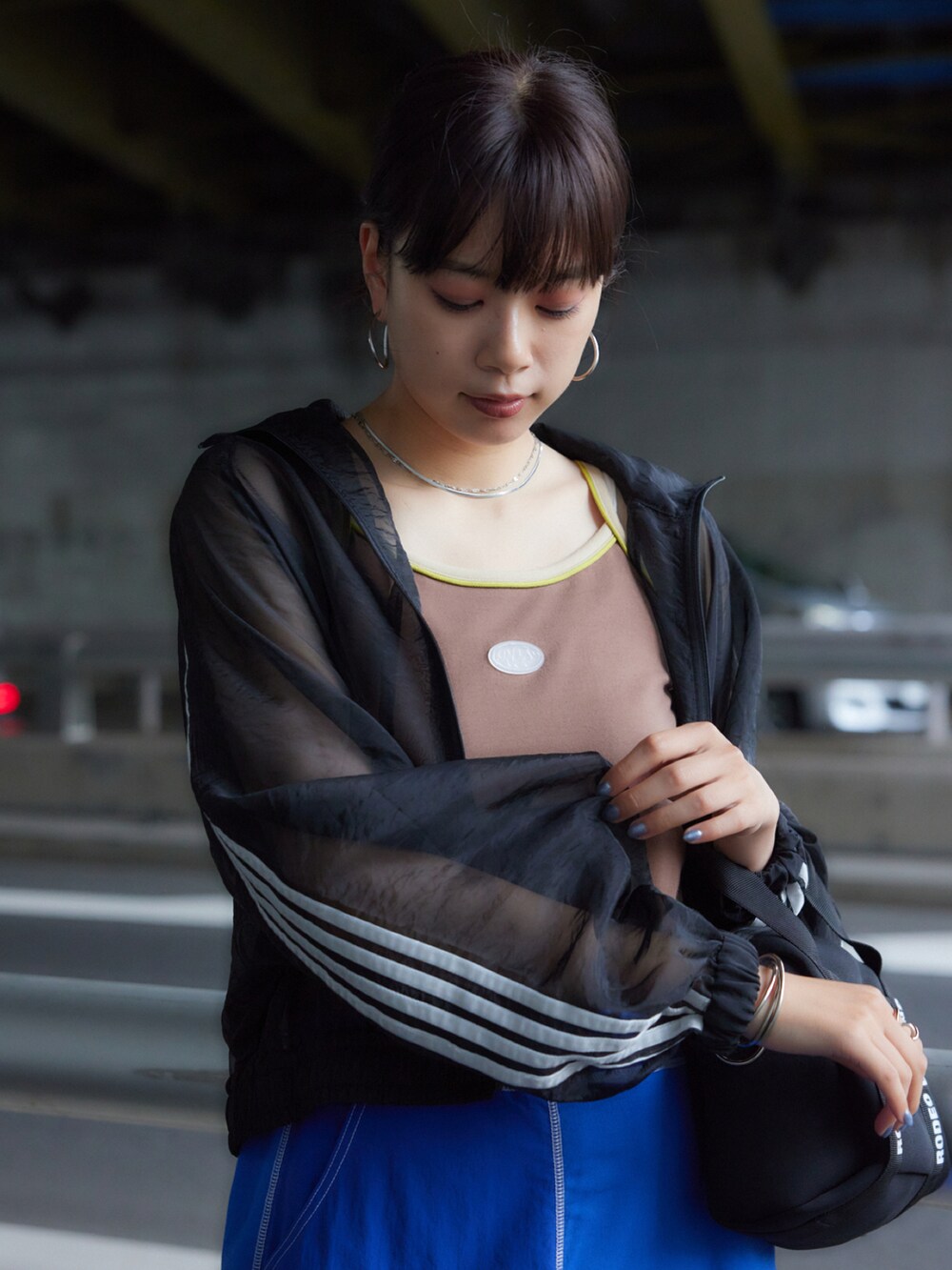 ブラック系のブルゾン、ブルー系のスカート、ブラウン系のキャミソールを着用したレディースの夏コーディネートの2枚目の写真