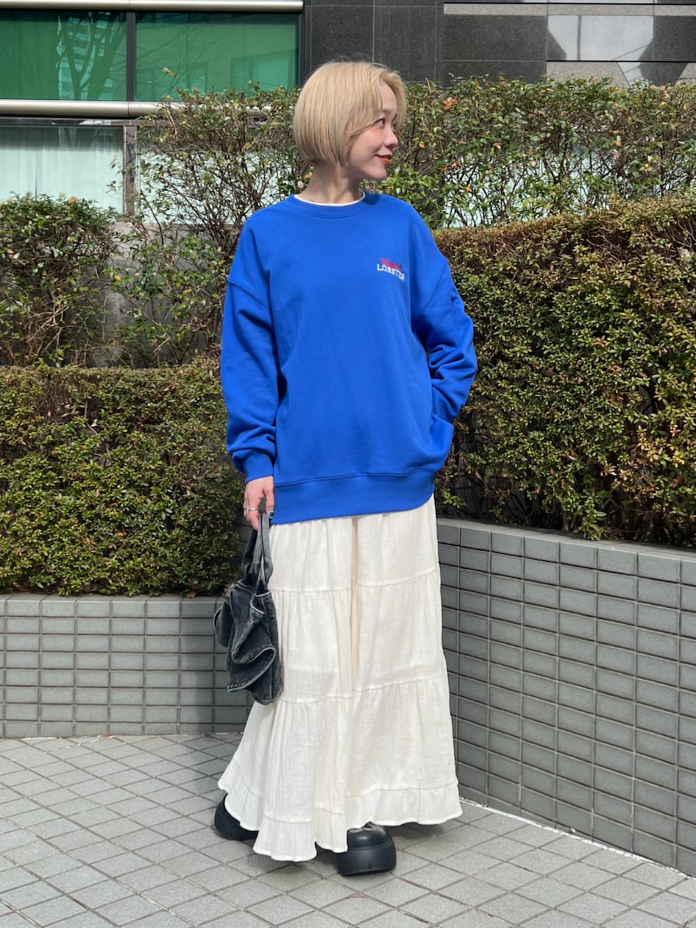 ブルー系のスウェット、ホワイト系のスカートを着用したレディースの冬コーディネートの3枚目の写真