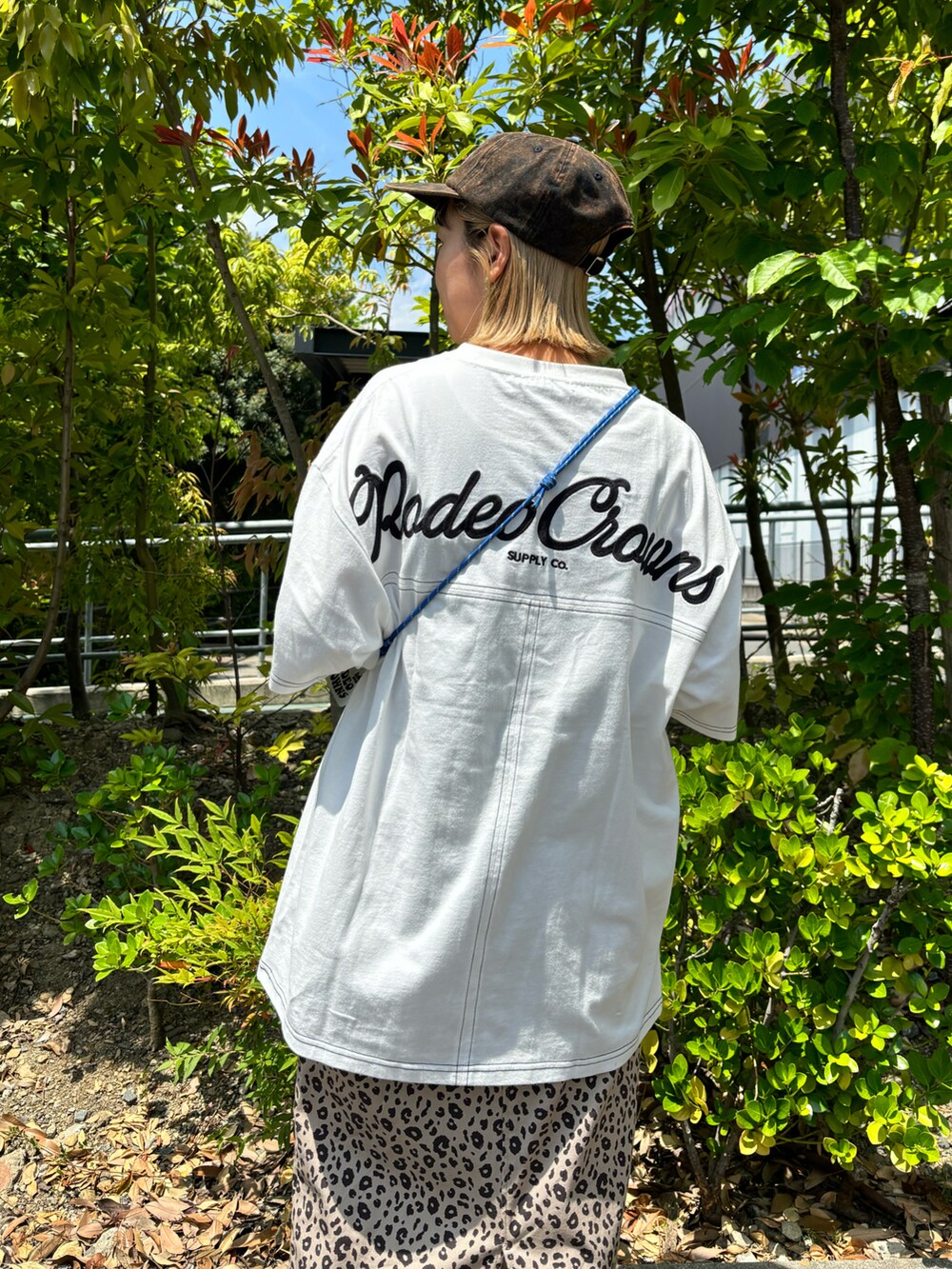 ホワイト系のTシャツ/カットソー、ベージュ系のスカート、ブラック系のショルダーバッグを着用したレディースの春コーディネートの3枚目の写真