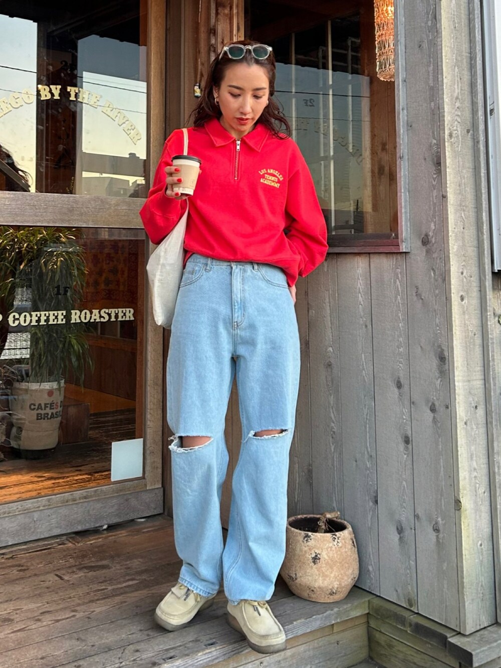 レッド系のスウェットを着用したレディースの冬コーディネートの3枚目の写真