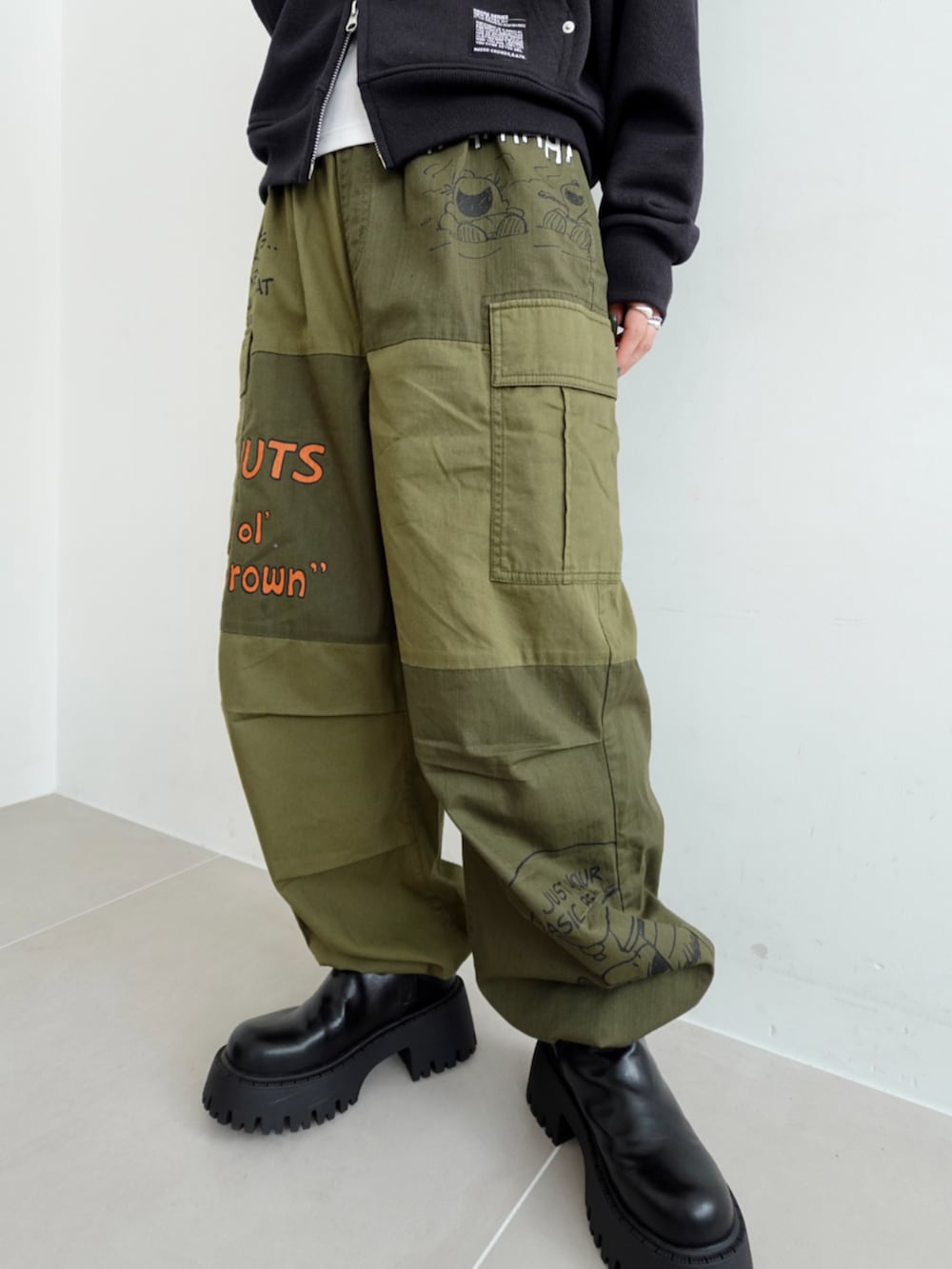 グリーン系のカーゴパンツ、ブラック系のパーカーを着用したレディースの秋コーディネートの3枚目の写真