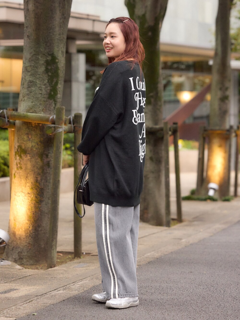 ブラック系のワンピース、ブラック系のデニムパンツ、ブラック系のショルダーバッグを着用したレディースの冬コーディネートの2枚目の写真